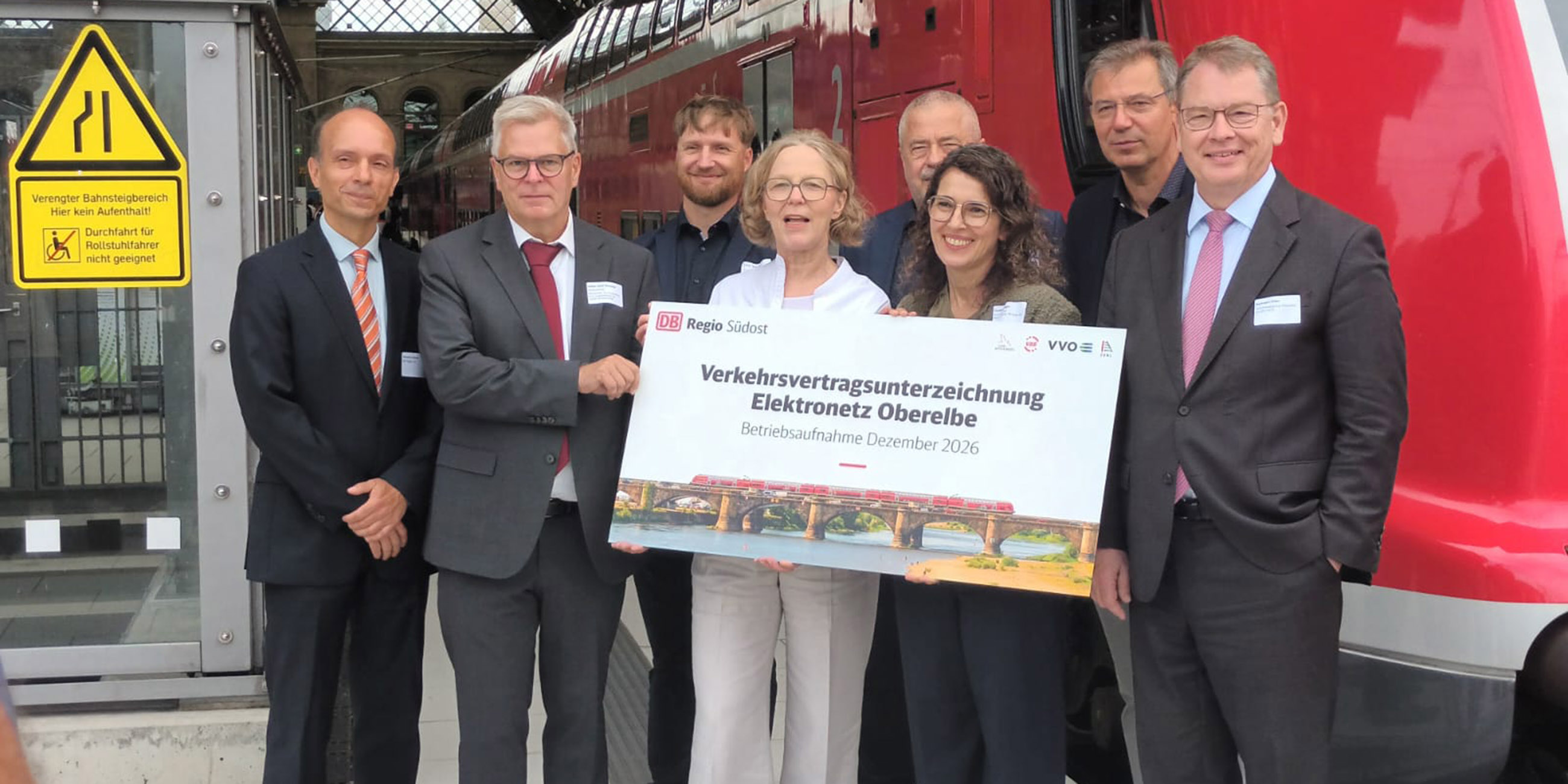 Personen und Vertragssymbol vor einem Zug