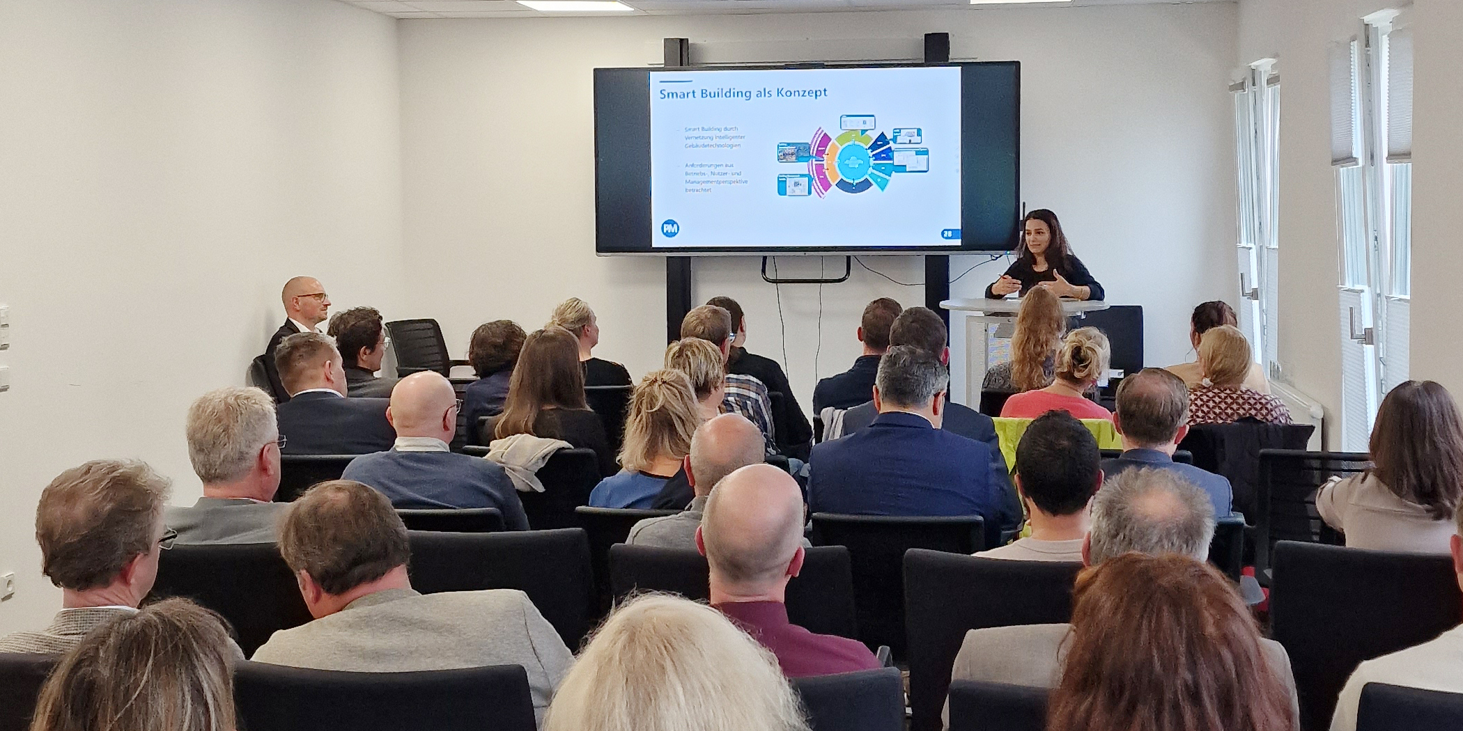 Sie sehen ein Bild der Teilnehmenden des BIM-Dialogforums. Die Zuhörenden blicken auf die vortragende Referentin.