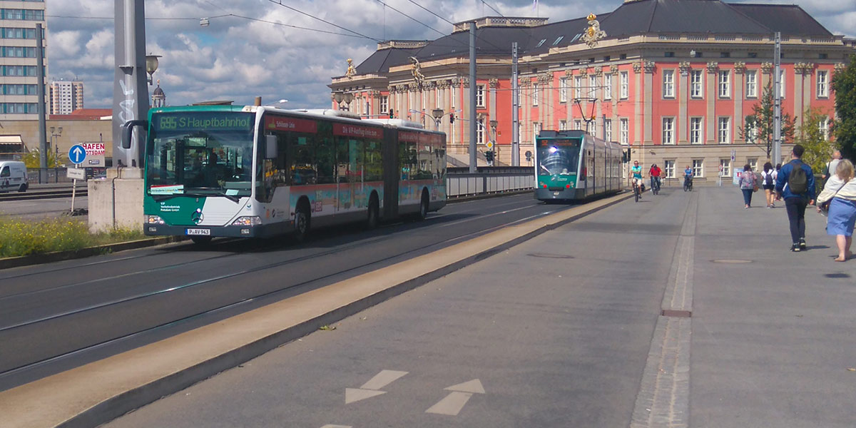 Ein Bus und eine Straßenbahn nutzen eine Fahrspur auf einer Brücke in der Innenstadt