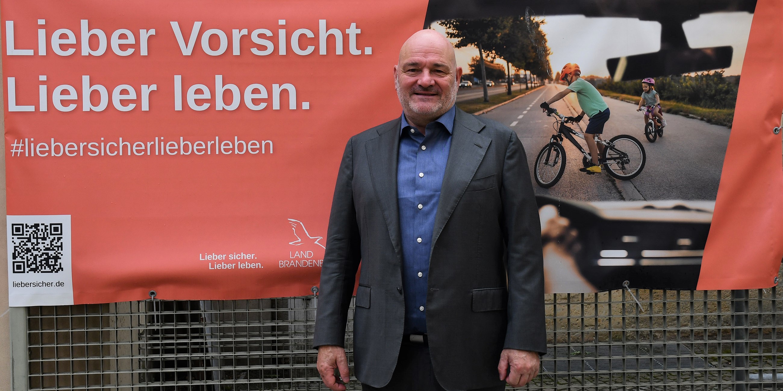 Verkehrsminister Robert Crumbach vor einem Banner der Verkehrssicherheitskampagne