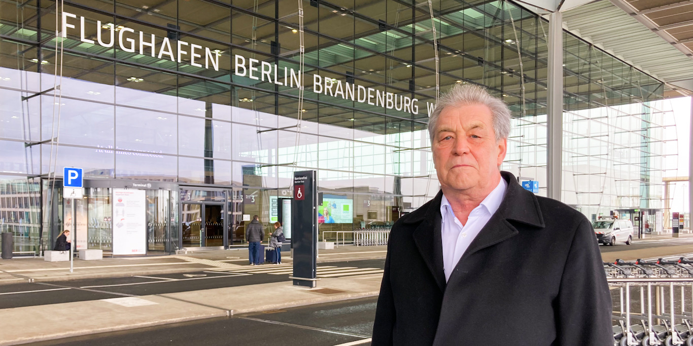 Klaus Wernicke steht vor dem Haupteingang des Flughafen Berlin Brandenburg