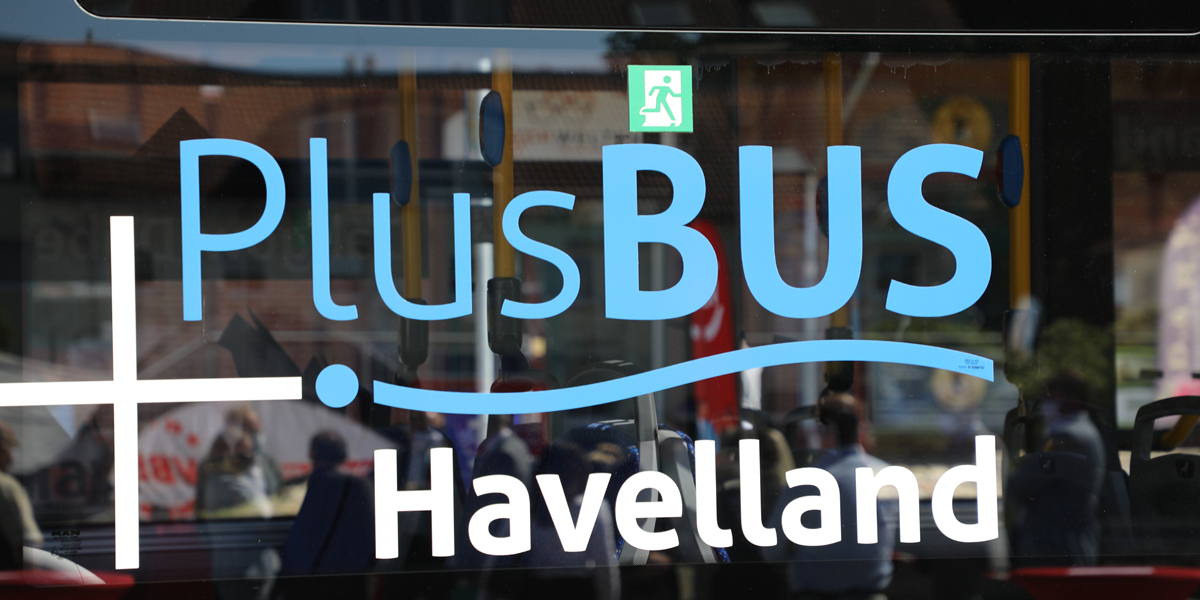 Das Logo von PlusBus Havelland auf einer Scheibe