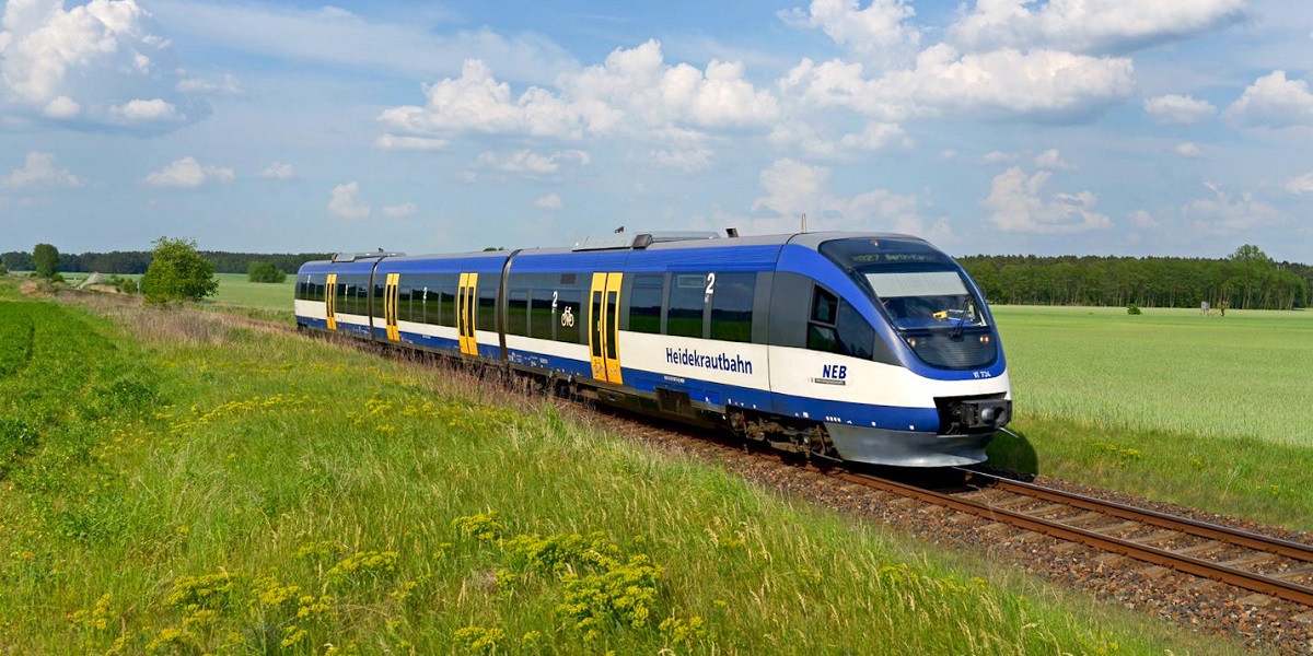 Die Heidekrautbahn, ein blauer Regionalzug, fährt durch die Landschaft im Norden Brandenburgs 