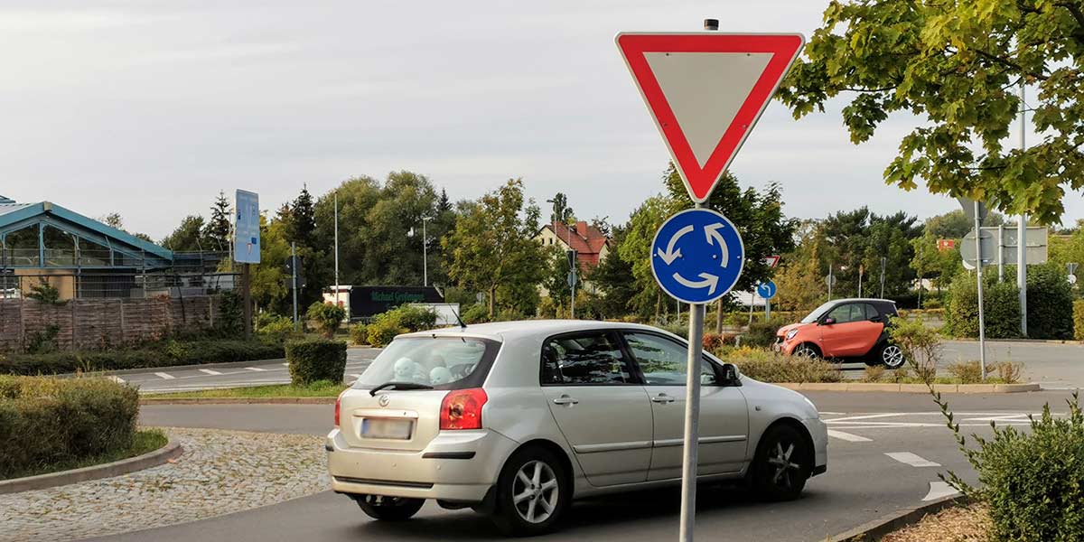 Ein Auto biegt aus einem Kreisverkehr in eine Straße ab
