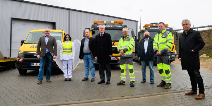Gruppenbild mit Verkehrsminister Beermann vor Abschleppfahrzeugen, die mit Abbiegeassistenten ausgerüstet wurden