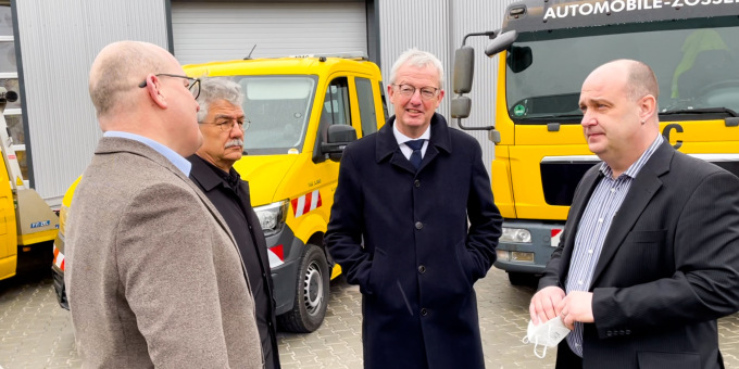 Minister Beermann im Gespräch vor Abschleppfahrzeugen, die mit Abbiegeassistenten ausgerüstet wurden, Herr Körper, Geschäftsführer der Automobile Zossen GmbH