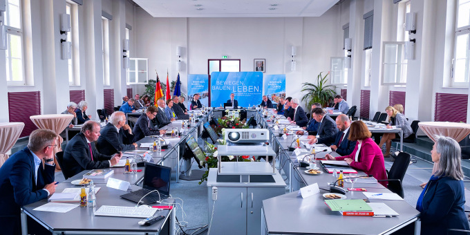 Ein Beratungssaal, die Bauministerinnen und Bauminister oder ihre Stellvertretenden am Beratungstisch sitzend 