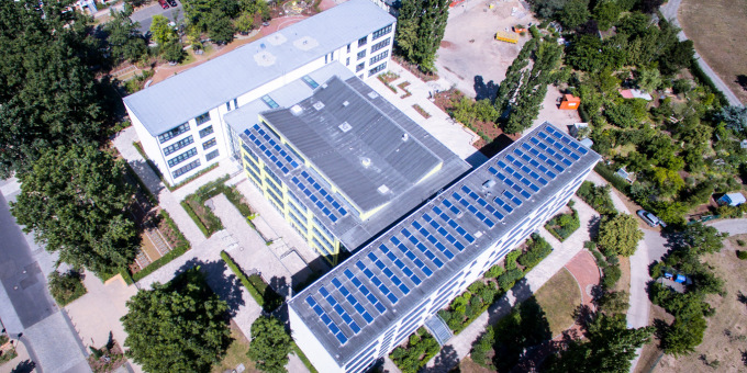 Schulgebäude von oben mit Solarzellen auf dem Dach 