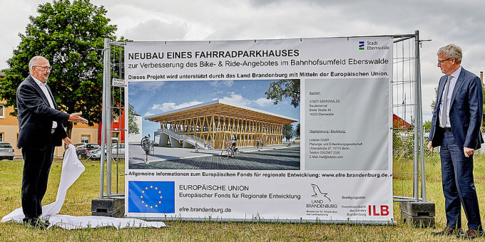 Minister Guido Beermann bei der Enthüllung des Schilds mit den Bauprojektinformationen.